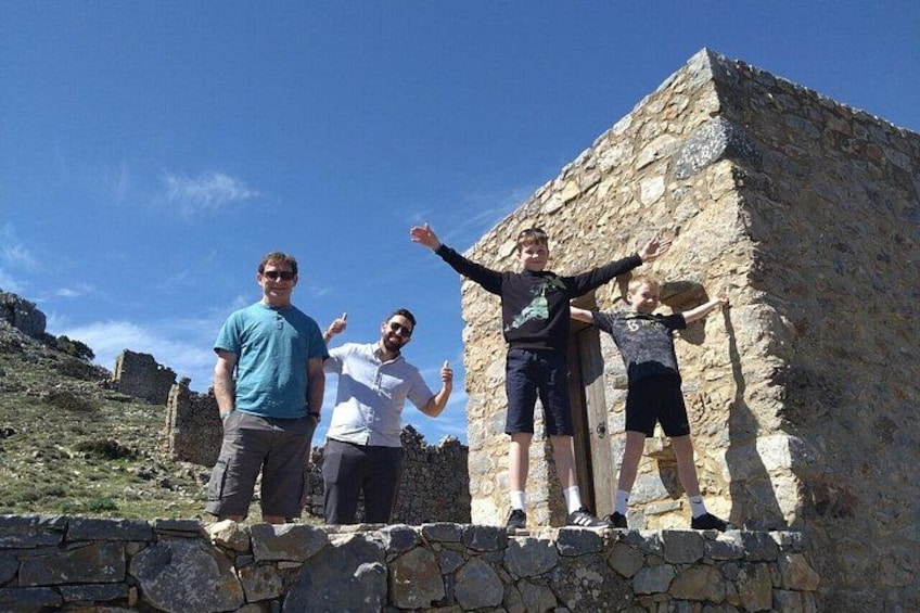 A group of people standing on a stone wall with a stone building in the background. 5