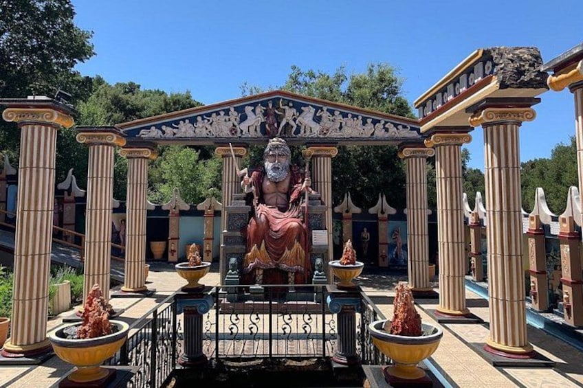 A classical statue in a garden with columns and a fountain. 4