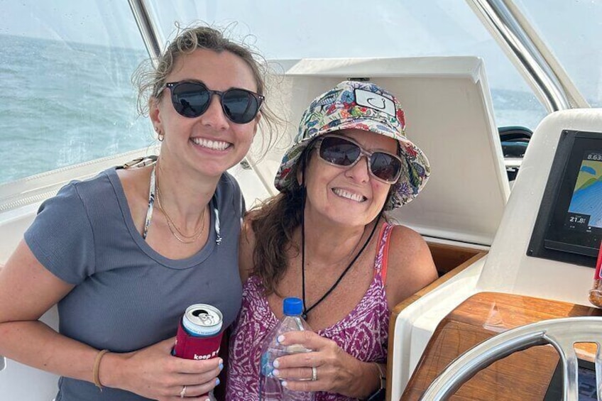 Two people on a boat holding drinks. 1