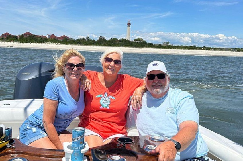 Three people on a boat with a lighthouse in the background. 3