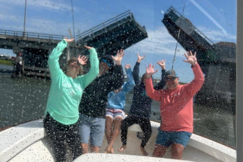 People on a boat with water splashing around them. 2