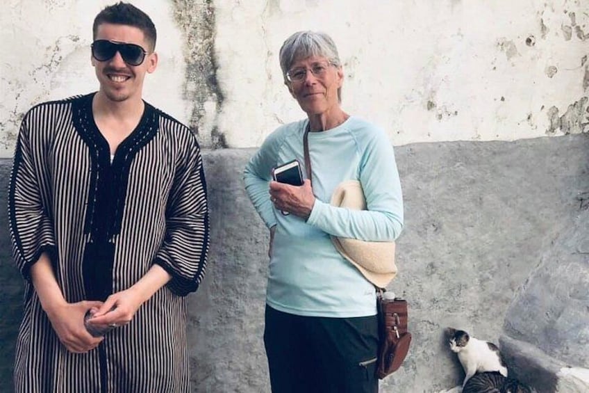 Zwei Personen stehen da, eine hält ein Buch und die andere eine Tasche. 2