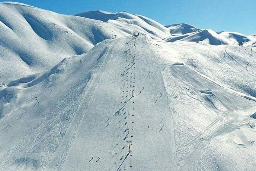Een met sneeuw bedekte berg met een skipiste. 3