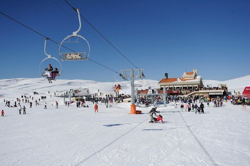 Een piste waar mensen skiën en een skilift in bedrijf is. 5