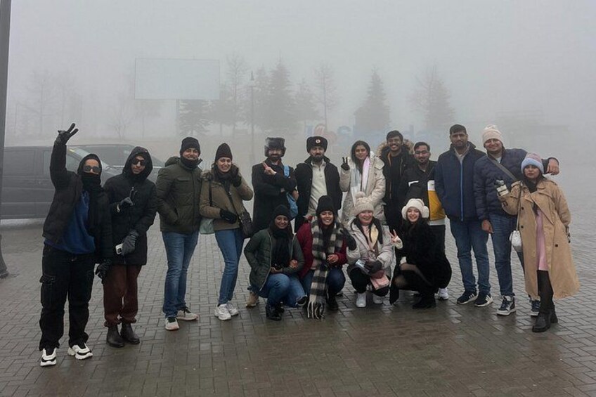Een groep mensen die voor een foto poseert in een mistige omgeving. 2