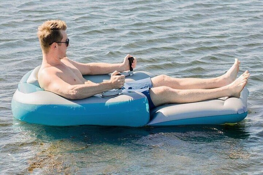 Una persona flota sobre una balsa inflable azul en aguas tranquilas. 4