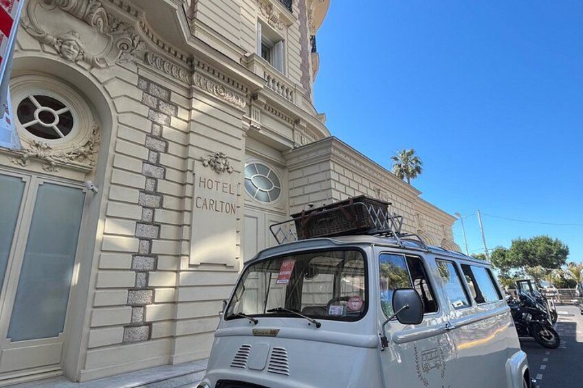 A vintage van parked in front of a building with a sign that reads 'HOTEL CARLTON.' 3
