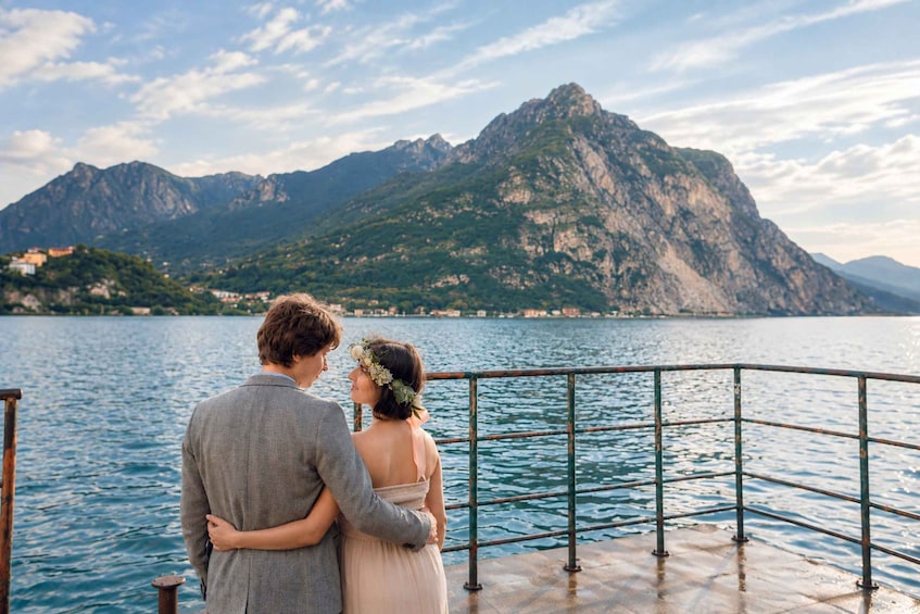 Un couple s’embrasse sur un bateau, avec un paysage montagneux en arrière-plan. 2