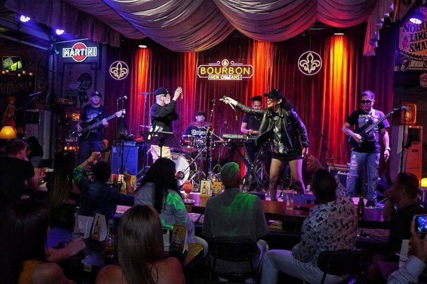 A band performing on a stage with a crowd watching. 1
