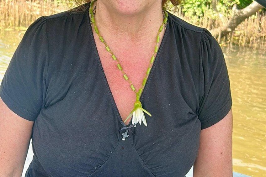 A person wearing a black top with a green necklace. 5