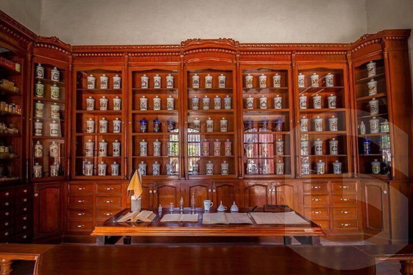 A wooden cabinet with glass doors filled with ceramic containers. 4