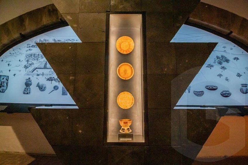 A display of pottery with a central light fixture. 3