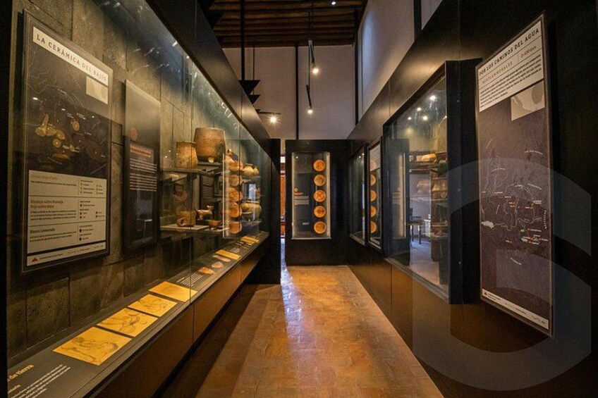 Un corridoio di un museo con vetrine in vetro che espongono reperti in ceramica. 4
