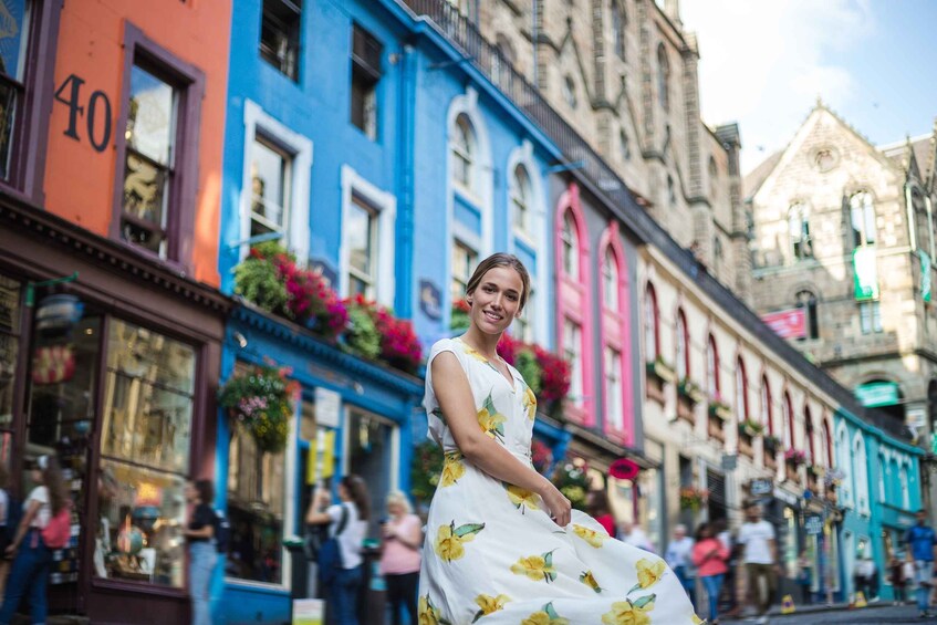A woman in a white dress with yellow flowers walking on a colorful street. 1