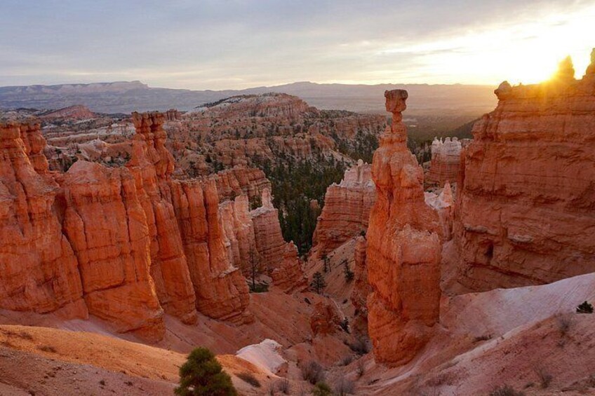 Un canyon aux formations rocheuses rouges, avec un coucher de soleil en arrière-plan. 2