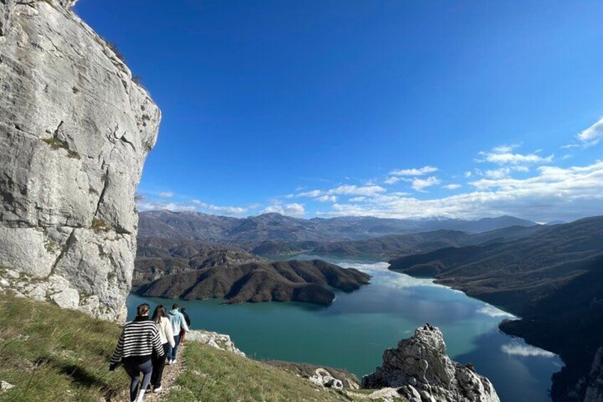 A rocky cliff, a lake, and a mountainous landscape. 3