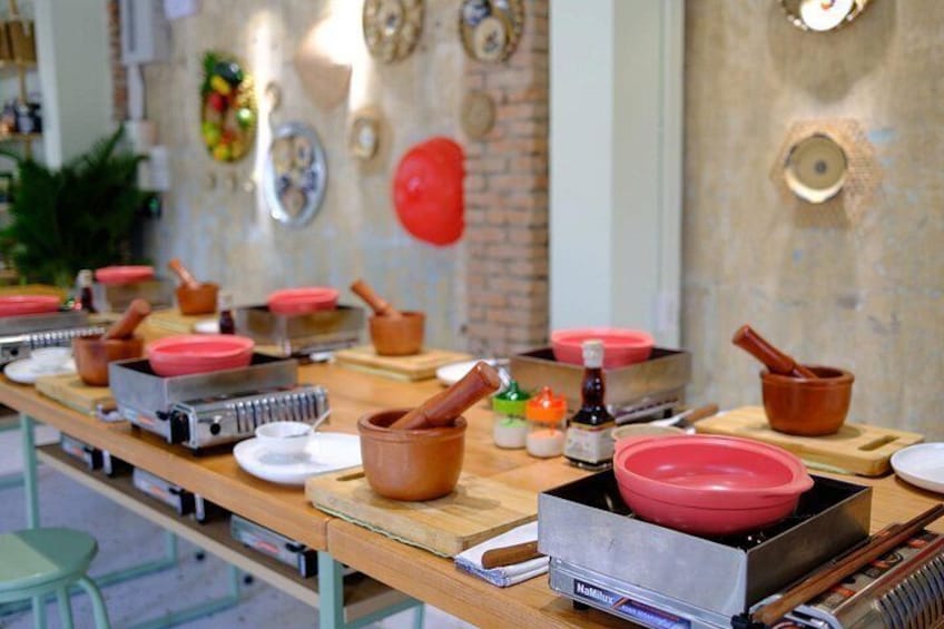 Une cuisine avec des ustensiles de cuisine, des casseroles et des assiettes sur une table en bois. 5