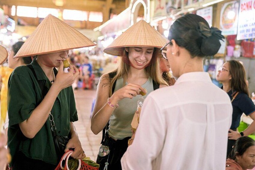 Personas en un mercado, interactuando y comprando, usando sombreros cónicos tradicionales. 2