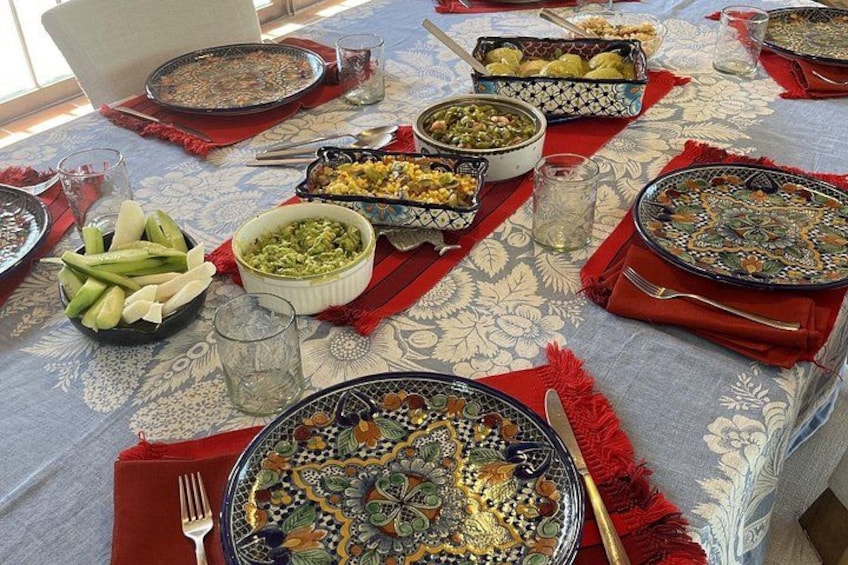 A table set with various dishes, including a large ornate plate, bowls, and glasses. 2