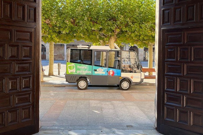 A Tours guiados bus parked at a wooden door entrance. 2