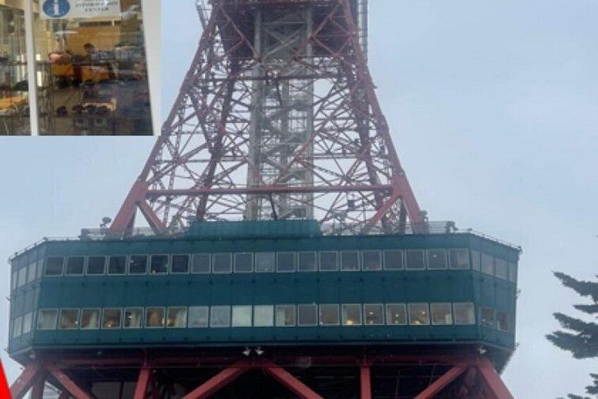 A large industrial tower with a blue structure at its base and a red metal framework. 2