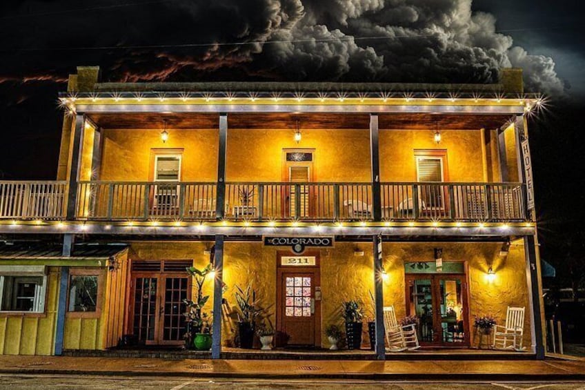 A two-story building with a balcony, illuminated by string lights, and a sign that reads 'COLORADO.' 3