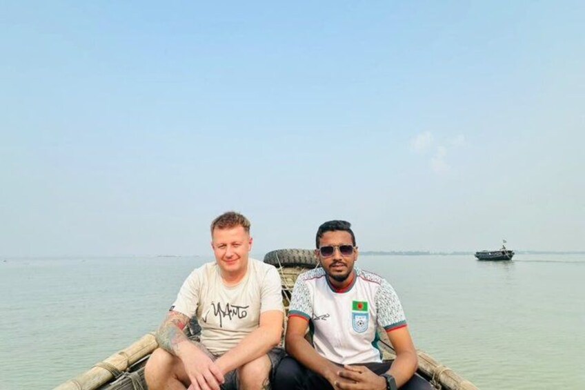 Two people sitting on a boat in calm water with a distant ship. 3