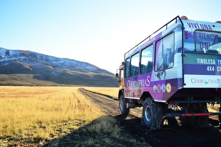 En fyrhjulsdriven bil med texten ”Cerro Frías” på sidan, körandes på en grusväg i ett bergigt område. 1