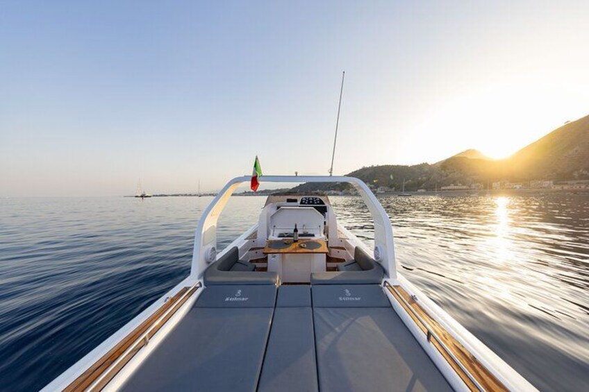 A boat on calm water with a sunset in the background. 5