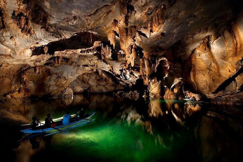 A cave with stalactites and stalagmites, a canoe, and a person in a kayak. 2