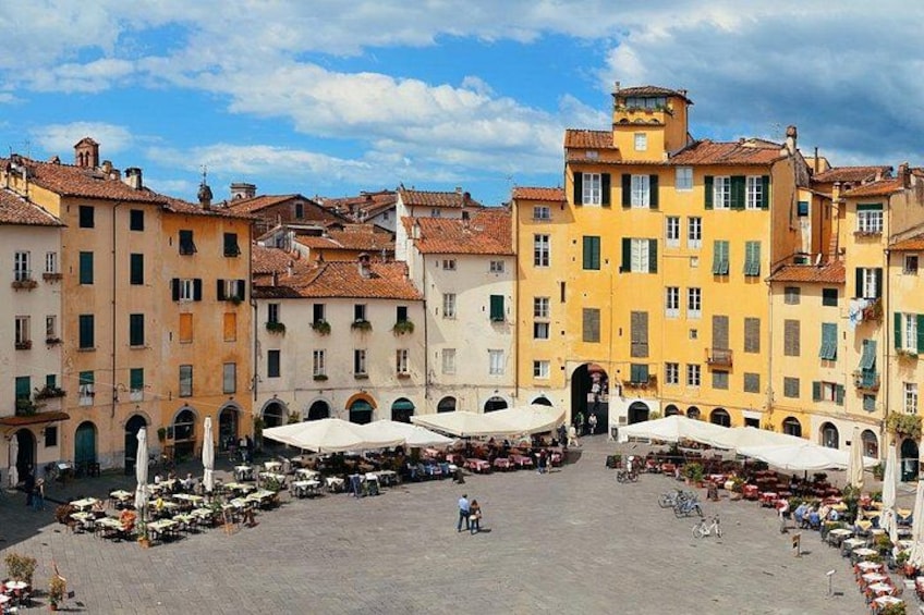 A square with outdoor cafes, historic buildings, and a fountain. 2