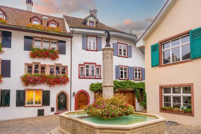 A courtyard with a fountain, flower boxes, and a statue. 5