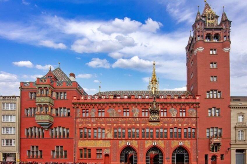 A red building with ornate architecture and a tower with a golden spire. 1