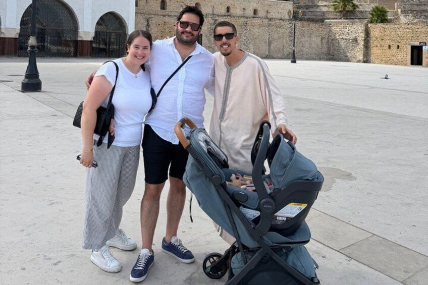 Three people standing in a plaza with a stroller. 5