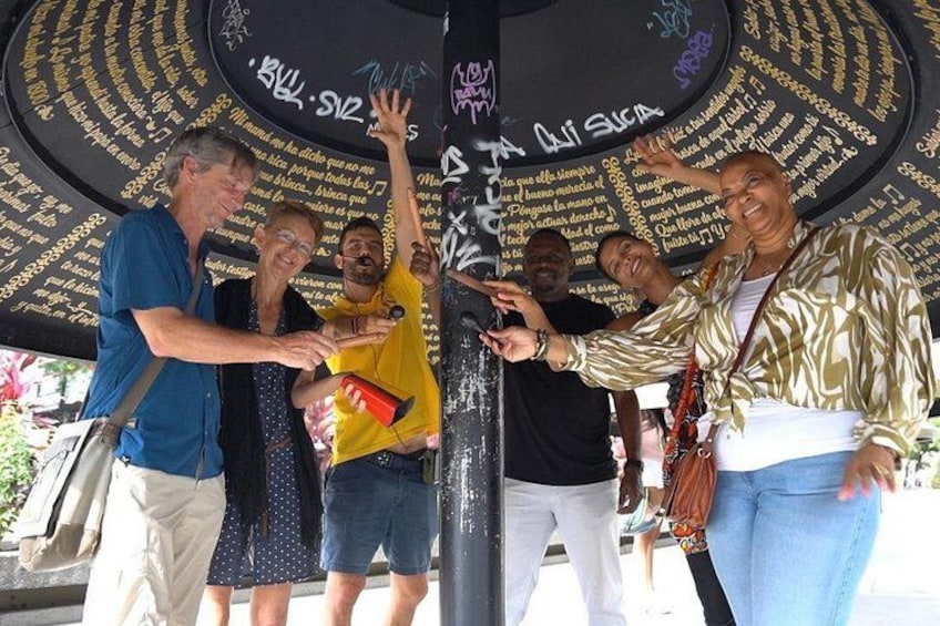 Un grupo de personas interactuando con una estructura circular cubierta de texto. 1
