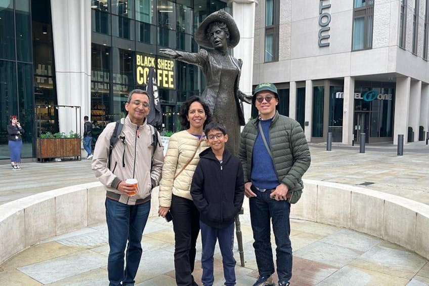 En gruppe mennesker står foran en statue og en bygning med et skilt, der siger 'Black Sheep Coffee'. 5