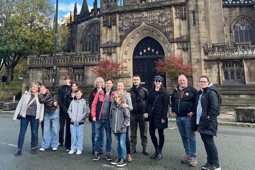 Un gruppo di persone in piedi di fronte a un edificio storico caratterizzato da un'architettura elaborata. 5