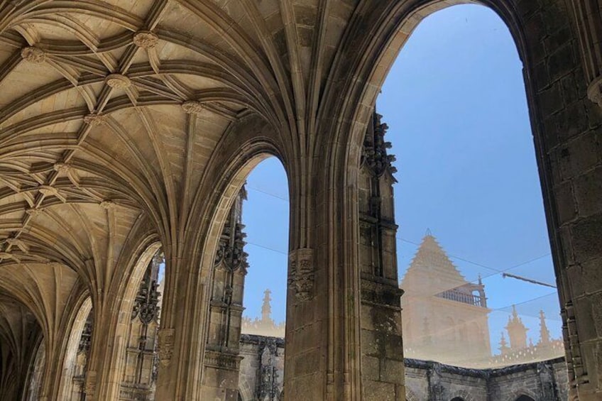 Interno di una cattedrale con archi gotici e vista aperta verso l'esterno. 2