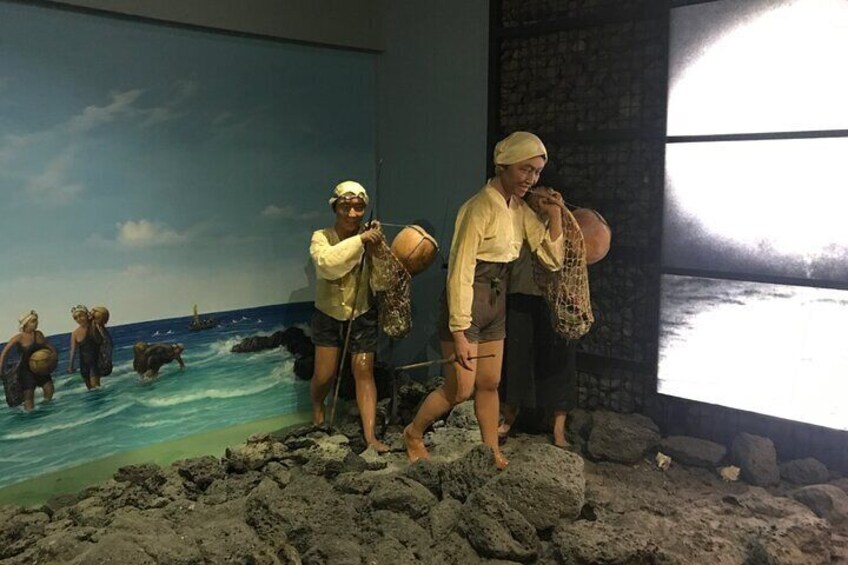 A beach scene with people fishing and a mural in the background. 5