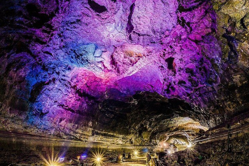 Una cueva con iluminación colorida y formaciones rocosas. 5