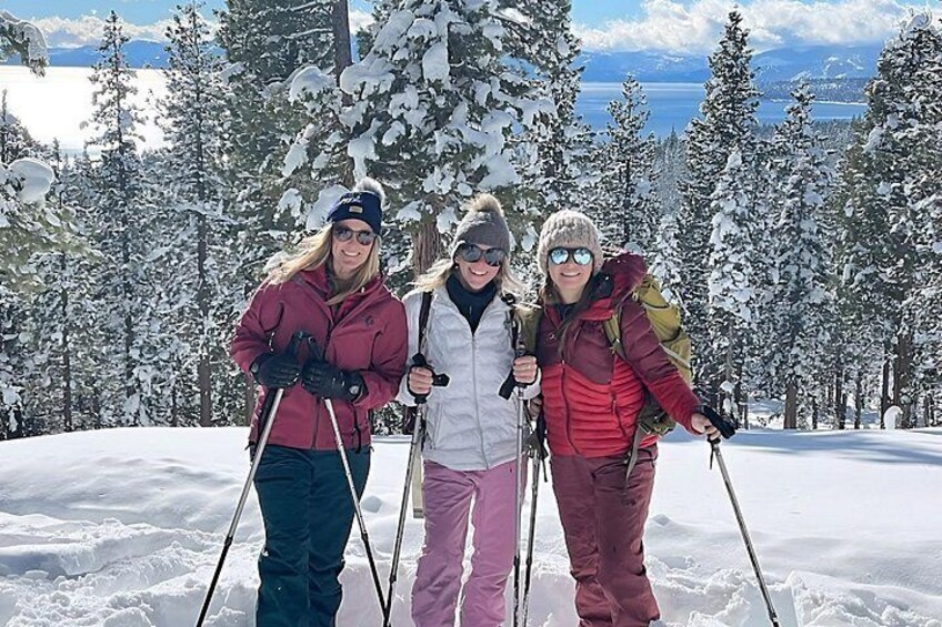 Three people skiing on a snowy slope with evergreen trees in the background. 1