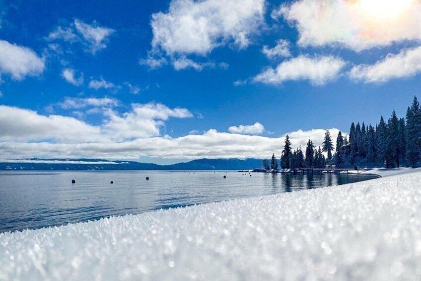A snowy landscape with a lake, trees, and a clear sky. 3