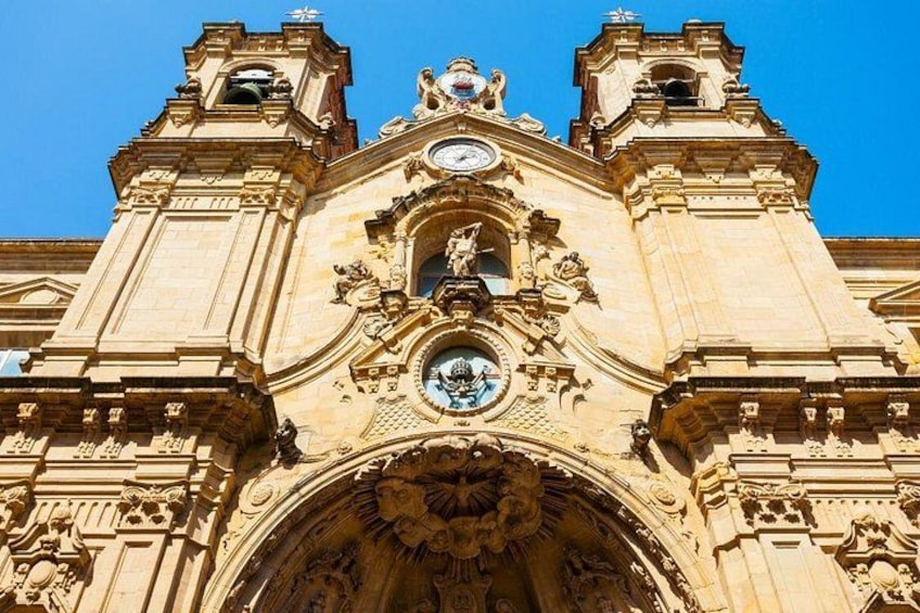 A historic building with ornate architecture, including a large arched entrance and two bell towers. 3