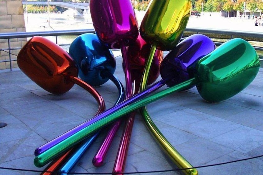 A collection of colorful, reflective sculptures on a tiled surface. 5