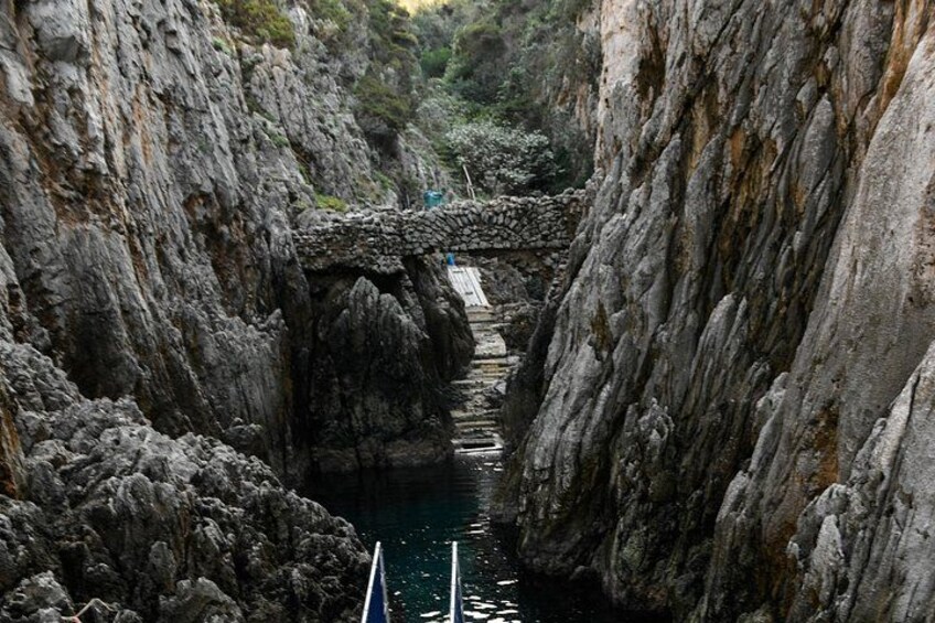 Un cañón estrecho con un puente de piedra sobre un río. 3