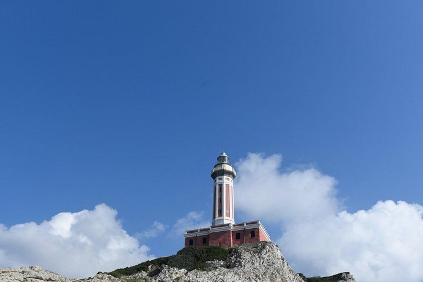 Un faro sobre un promontorio rocoso, con cielo azul despejado. 5
