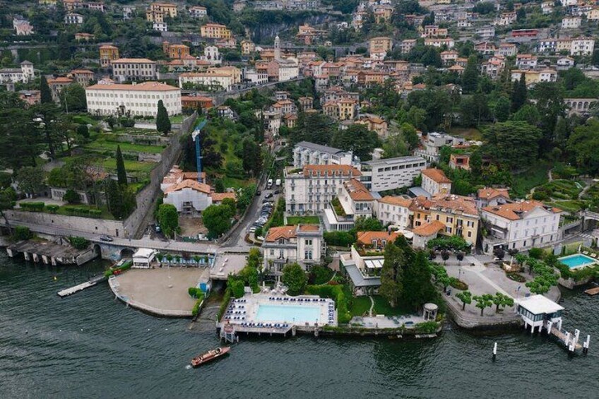 Vista aérea de un pueblo costero con edificios, un puerto deportivo y una gran piscina. 2