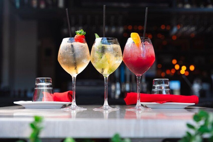 Trois cocktails sont posés sur une table, avec en arrière-plan une vue floue de la ville. 3