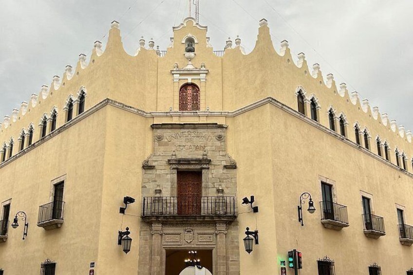 Een historisch gebouw met een opvallende gevel, een centrale ingang en decoratieve details. 4