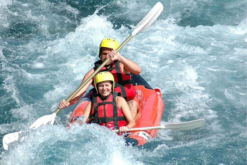 Two people kayaking in rough water. 4